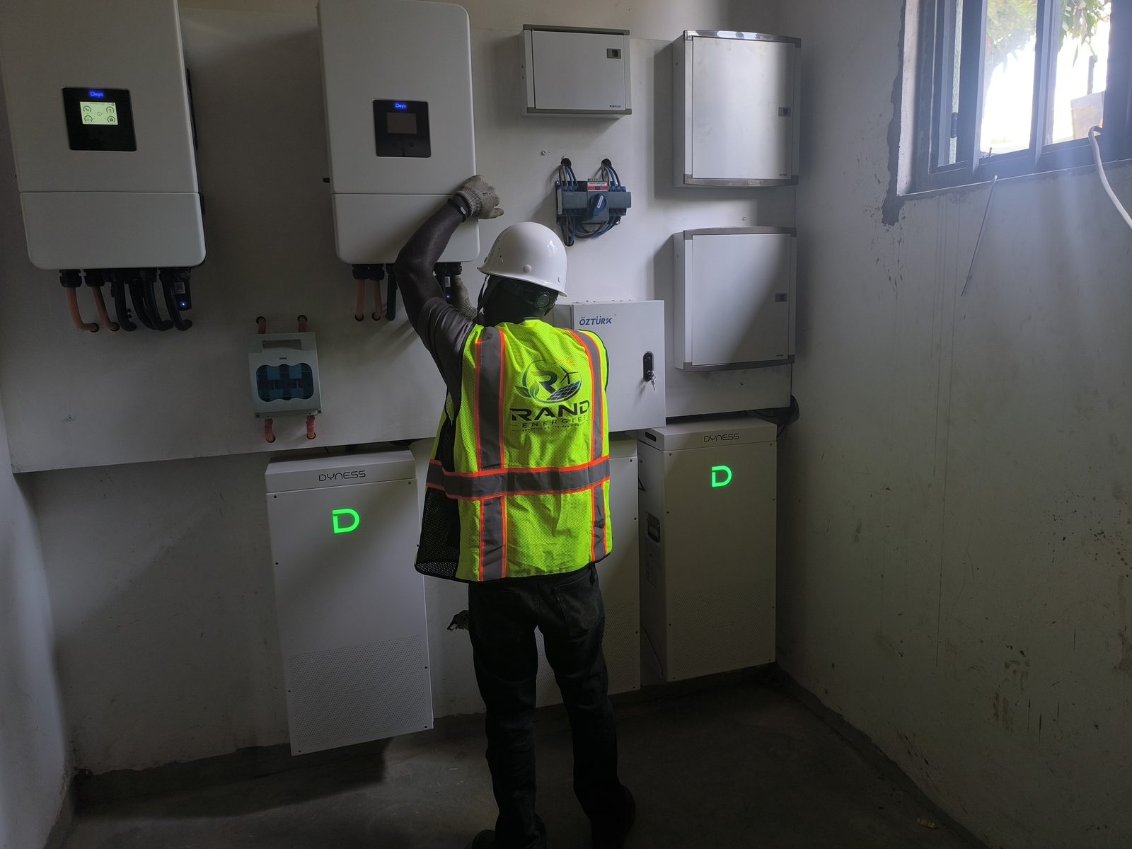 Rand Energies technician commissioning a Deye hybrid inverter with Dyness battery storage